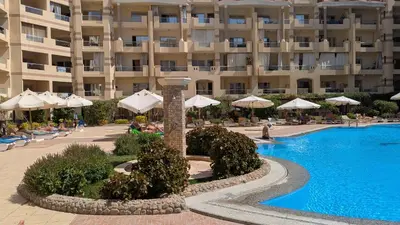 a hotel with a swimming pool in front of a building at Studio Apartment Flourenza Hurghada in Hurghada