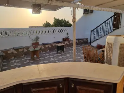a room with a balcony with tables and chairs at Adream partment in Luxor in Luxor