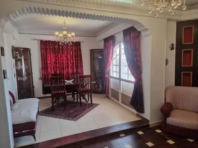a dining room with a table and red curtains at Adream partment in Luxor in Luxor