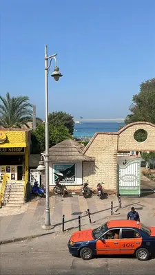an orange and black car parked in front of a building at La Blanca in Hurghada