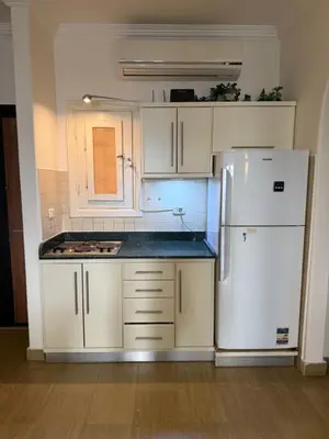 a kitchen with white cabinets and a white refrigerator at Red Sea Horizon in Hurghada