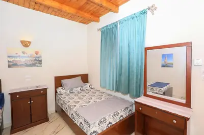 a small bedroom with a bed and a mirror at Tohamy house in Al Aqālitah