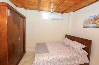 a bedroom with a bed and a wooden cabinet at Tohamy house in Al Aqālitah