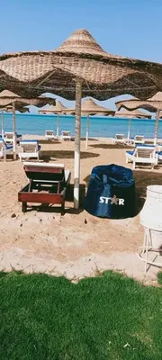 a beach with a table and chairs and an umbrella at كازابلانكا ستار in Hurghada