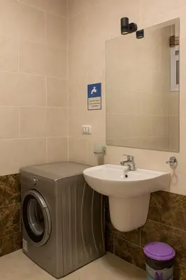 a bathroom with a sink and a washing machine at Hurghada concierge at La Prestigia B2 4 in Hurghada