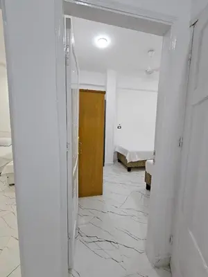 a hallway with a door and a room with a bed at Hatshepsut Apartments Luxor in Luxor