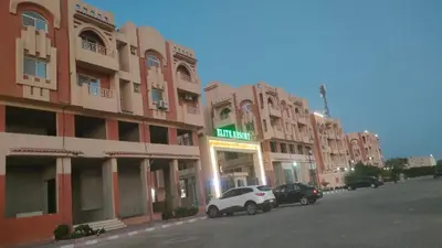 a row of buildings with cars parked in front of them at Elite House in Hurghada
