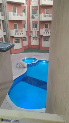 a large swimming pool in front of a building at Elite House in Hurghada