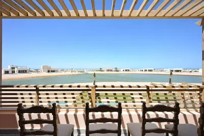 two chairs sitting on a porch looking at the beach at Stunning 3 bd penthouse with private pool - El Gouna in El Gouna