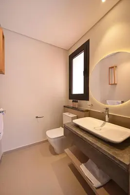 a bathroom with a sink and a toilet and a mirror at Stunning 3 bd penthouse with private pool - El Gouna in El Gouna