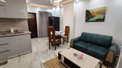 a living room with a green couch and a table at Stylish Sunny Central 1BR in Hurghada
