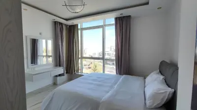 a bedroom with a white bed and a large window at Stylish Sunny Central 1BR in Hurghada