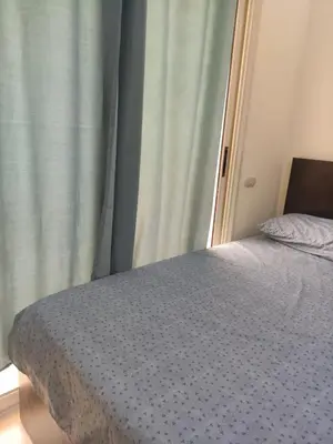 a bedroom with a bed with a blue comforter and a window at Florenza Khamsin Sea front in Hurghada