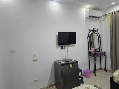 a room with a small refrigerator and a tv on the wall at Florenza Khamsin Sea front in Hurghada