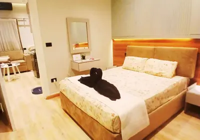 a bedroom with a bed with a black robe on it at Modern Sea View Palma House Steps from Dream Beach in Hurghada