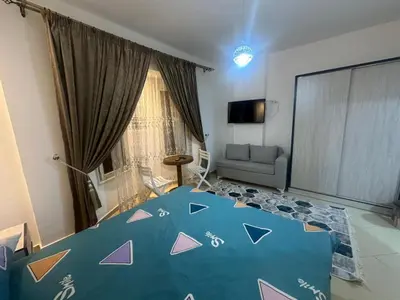 a bedroom with a blue bed with triangles on it at Balkan Resort in Hurghada