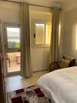 a bedroom with a bed and a view of the ocean at Tut Apartment in Luxor