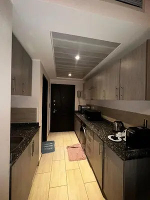 a kitchen with wooden cabinets and a counter top at Aldau heights Hurghada in Hurghada