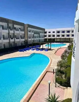 a large swimming pool in front of a building at سيسليا بيتش ريزورت in Hurghada