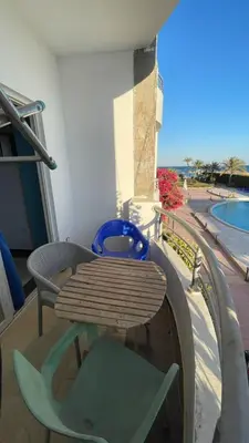 a table and chairs on a balcony with a pool at سيسليا بيتش ريزورت in Hurghada