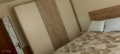 a bedroom with a bed with a wooden head board at جولدن طيبه الذهبيه in Hurghada