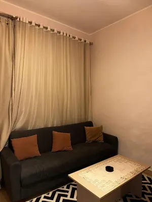 a living room with a black couch and a table at Aldau heights Hurghada in Hurghada