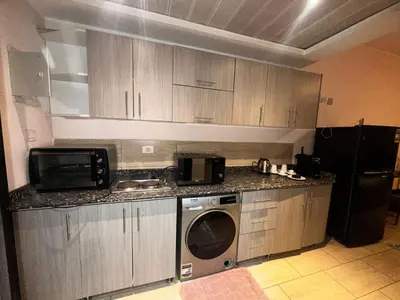 a kitchen with a microwave and a washer and dryer at Aldau heights Hurghada in Hurghada