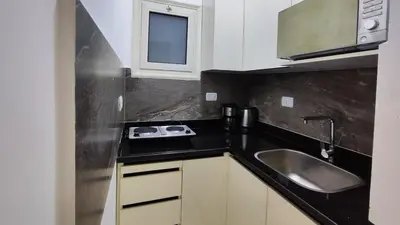 a small kitchen with a sink and a microwave at Comfort quiet central new flat in Hurghada