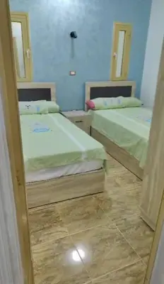 two beds in a room with a mirror at الغردقة منطقه عربيا شارع العشريني بجوار كافية فيلو in Hurghada