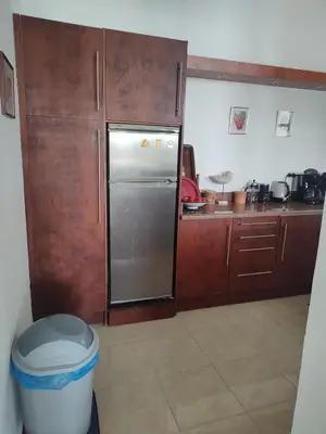 a kitchen with a stainless steel refrigerator and wooden cabinets at Antique apartment with sea view in Hurghada