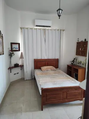 a bedroom with a bed and a white curtain at Antique apartment with sea view in Hurghada