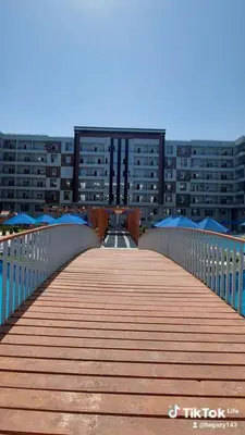 a wooden bridge in front of a large building at Golden Tiba in Hurghada