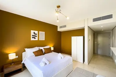 a bedroom with a large white bed and yellow walls at The Golden Atrium 3BDR Pool View Free Pool & Beach Access in Hurghada