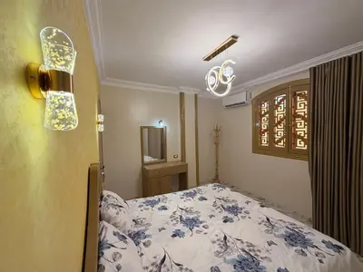 a bedroom with a bed and a chandelier at Oscar Apartment 9 in Luxor