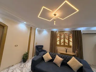 a living room with a blue couch and a table at Oscar Apartment 9 in Luxor
