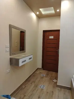 a bathroom with a mirror and a wooden door at Hurghada - star beach water front chalets - 3BR in Hurghada