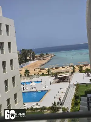 a view of a beach and a building and the ocean at Scandic in Hurghada