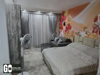 a bedroom with a bed and a living room at Scandic in Hurghada