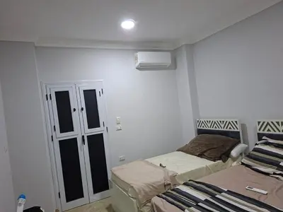 a small room with two beds and a window at Luxury family apartment in Hurghada in Hurghada