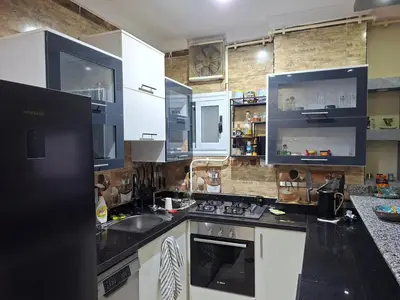 a kitchen with white cabinets and black counter tops at Luxury family apartment in Hurghada in Hurghada