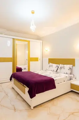 a bedroom with a large bed and a mirror at Oscar Apartment 8 in Luxor