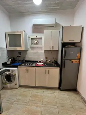 a small kitchen with a refrigerator and a sink at one bedroom at magawish hurghada in Hurghada