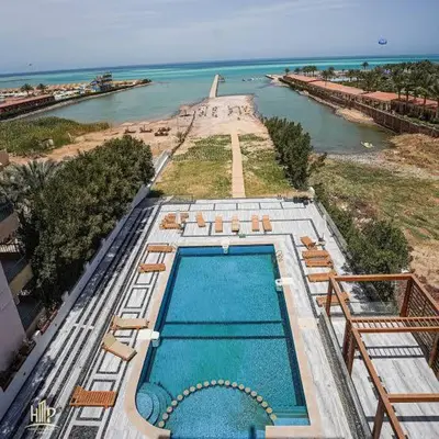 an overhead view of a swimming pool next to the ocean at Modern Studio with Pool and Private Beach Access in Hurghada