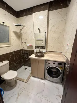 a bathroom with a washing machine and a toilet at الوفاء امام فندق بيروت in Hurghada