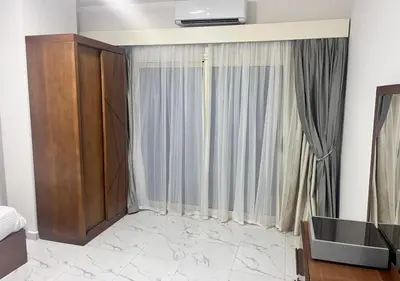 a living room with a large window with curtains at Juliana Golden Beach Resort in Hurghada
