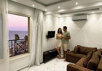a man and a woman standing in a living room at Juliana Golden Beach Resort in Hurghada