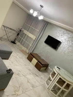 a living room with a couch and a television on the floor at Happy Home Hurghada in Hurghada