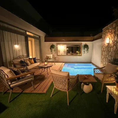 a living room with a pool with chairs and a table at one Bedroom with Private pool in Hurghada
