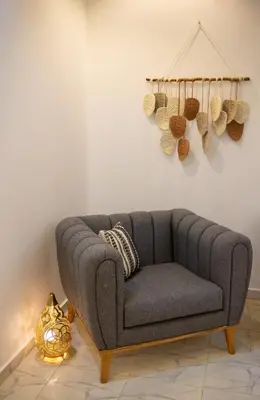 a gray couch sitting in a room next to a wall at Spacious and Chic 3 Bedroom Appartment Beautiful Rooftop Terrace Great location to explore Hurghada in Hurghada
