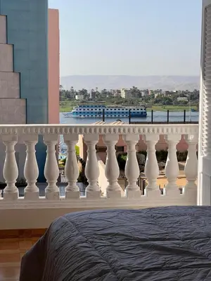 a balcony with a bed and a view of a train at Nile View Luxe Stay , Walk to Luxor Temple in Luxor